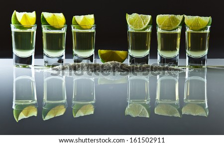 tequila , lime and salt on white reflexive table