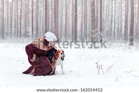 woman walk with dog in snowy forest