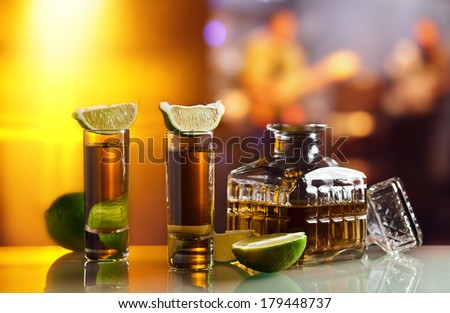 gold tequila and lime on glass table in nightclub