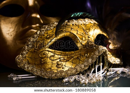Old gold Venetian masks on a glass table