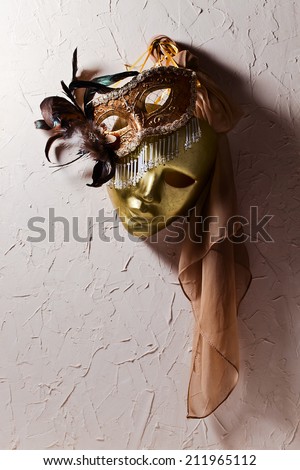 Two golden Venetian masks on  old wall