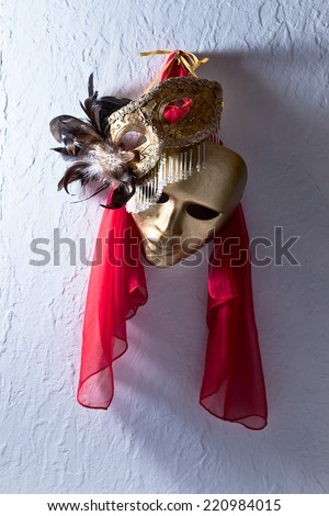 Two golden Venetian masks on  old wall