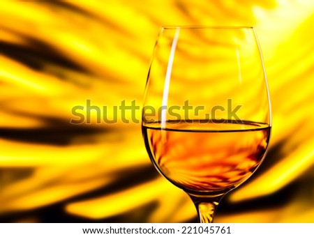 glass with white wine on yellow background