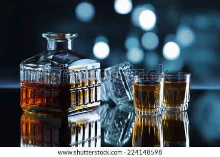 crystal glasses with whiskey on a dark background