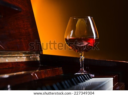 snifter with brandy on a old piano