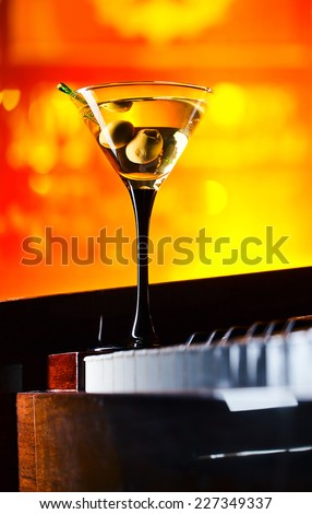 glass with martini on a old piano in bar