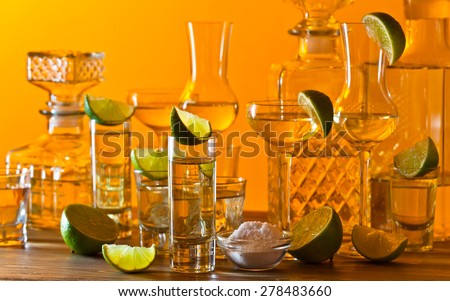 gold tequila , lime and salt on wooden table