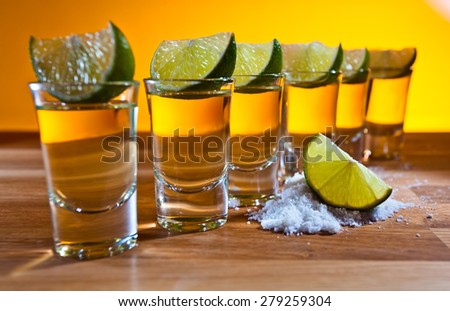 tequila , lime and salt on wooden table