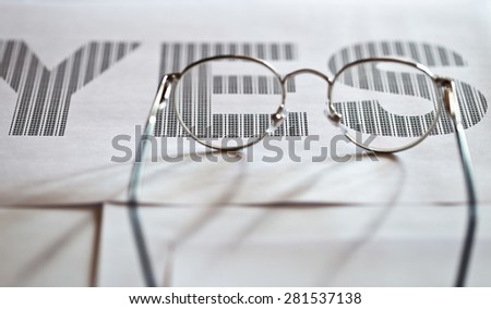 glasses and printed text on white paper,shallow DOF fokus on text