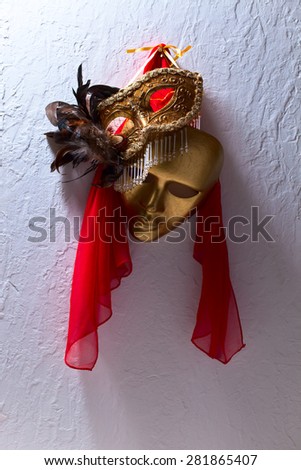 Two golden Venetian masks on a old wall