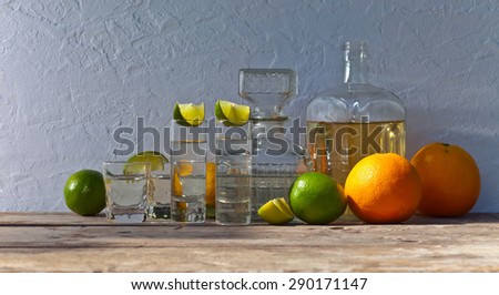 tequila and citrus fruits on old wooden table