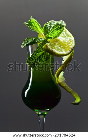 liquor with lime and peppermint on grey background