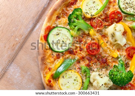 fresh baked vegan pizza on wooden shovel