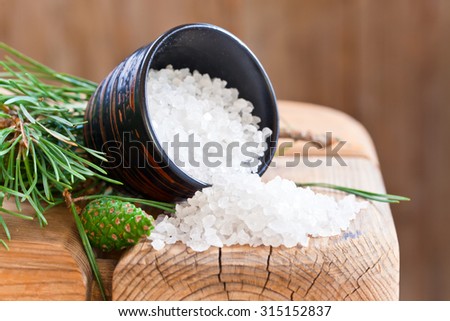 Sea salt and pine branch on an old wooden table