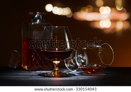 Snifter with brandy on black wooden table