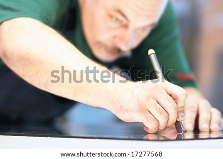 worker, cutting a mirror,fokus on a hand