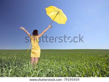 Young  girl with umbrella on a meadow. The polarising filter is used.