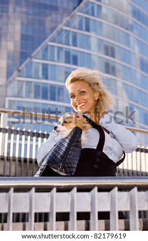 happy blond woman with chihuahua in downtown.