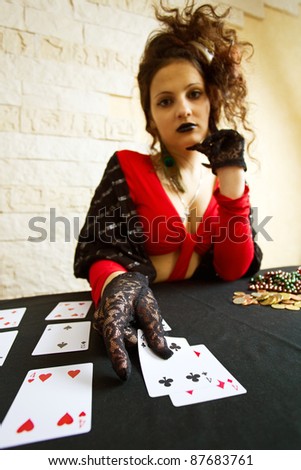 The young beautiful gypsy girl predicts the future on cards.Focus on a foreground.