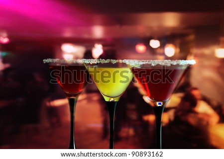 Three glasses with a cocktail in bar.
