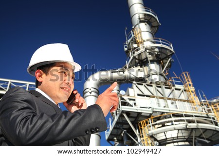 Industrial engineer communicate via mobile phone standing front of large factory