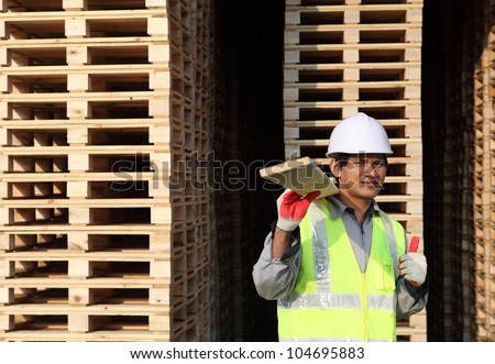 worker man moving wood in a warehouse