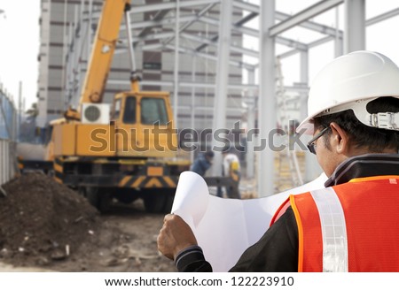 foreman checking plant on construction site with worker background and excavator