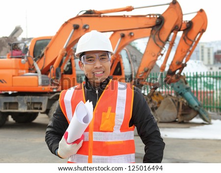 road construction worker holding blueprint and smiling