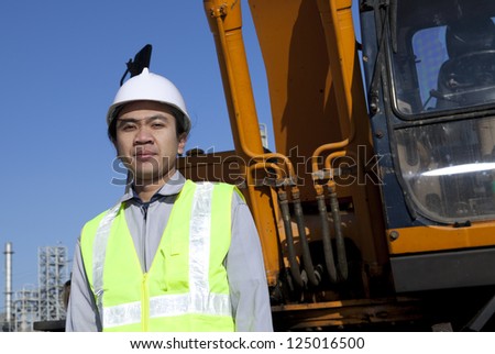 portrait construction worker standing front of heavy equipment