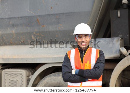 road construction worker smiling  a beside truck