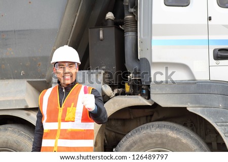 portrait  construction worker  showing thumb up smiling in beside truck