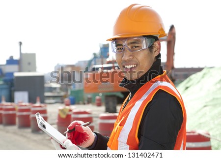 road construction worker  holding a  clipboard on the excavator background