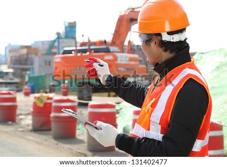 road construction worker and heavy equipment on the background
