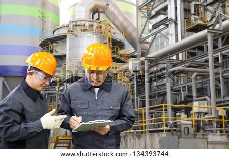 Two Engineer Discussing A New Project With Large Industry Background