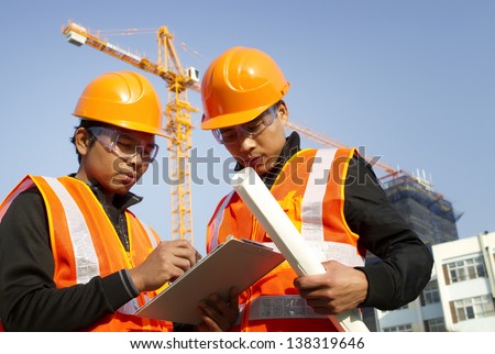 construction engineer with safety vest discussion under construction