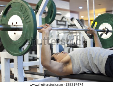 Man gym workout, using a squat machine at fitness club