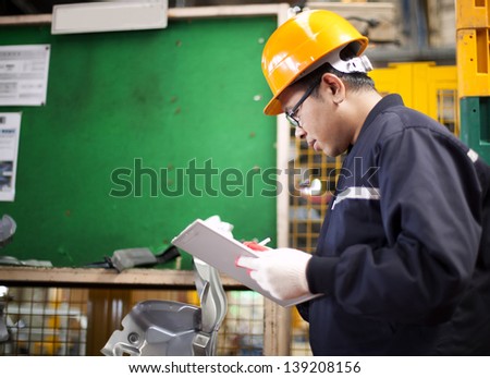 Portrait of asian engineer checking technical data in the factory