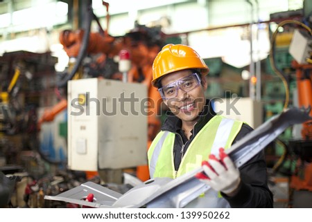 industrial engineer checking quality of metal in factory