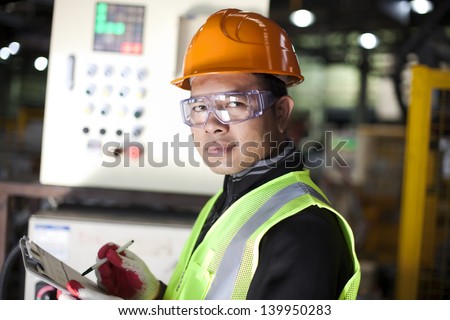Portrait of asian engineer taking notes in the factory