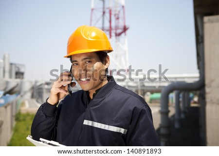 Chemical industrial engineer communication via phone looking at the camera
