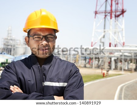 Chemical industrial engineer standing with oil refinery background