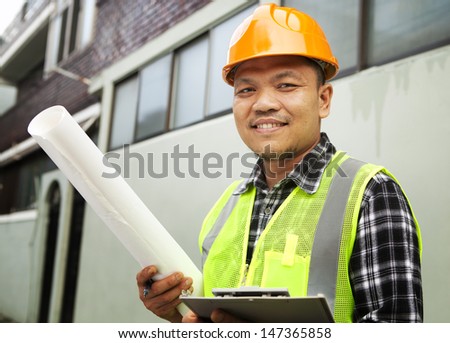 Male construction worker wearing safety vest at a building site