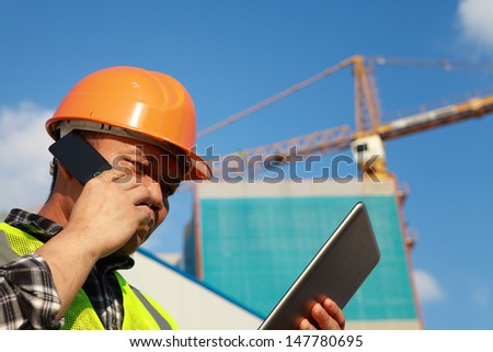 Construction Worker Activity With Mobile Phone And Digital Tablet
