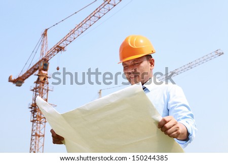 Construction worker manager check blueprint on building new site