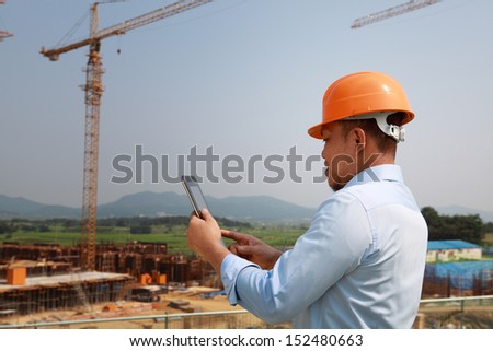 Manager using digital tablet on construction site
