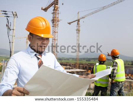 Construction manager checking plans  building project on site