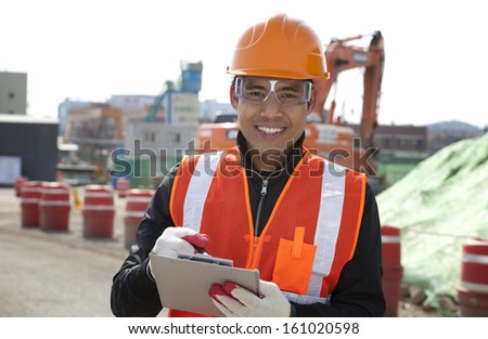 Smiling construction worker standing on construction   site