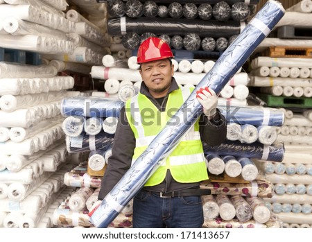 Textile factory worker carrying raw material fabric