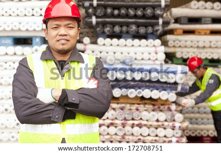 Textile factory worker standing  in warehouse fabrics