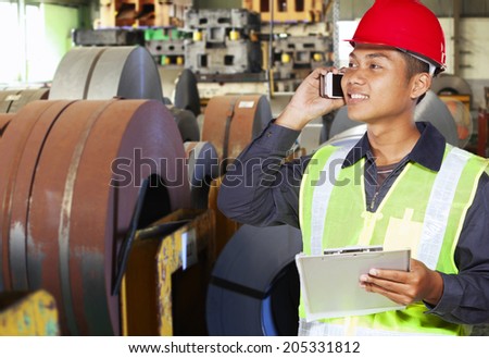 Industrial engineer communication via phone in factory